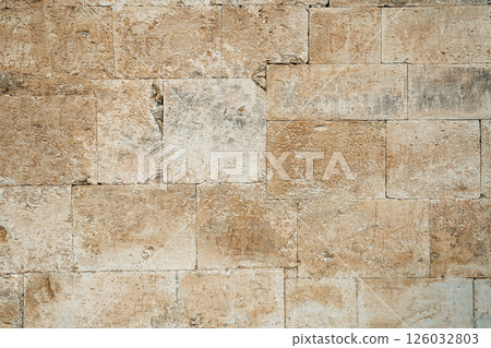 Antique ancient stone wall masonry texture background. Old wall made of beige stone blocks  126032803
