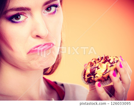 unhappy woman holds cake in hand 126033095