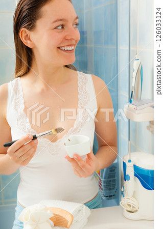 Woman applying mud facial mask Woman applying mud facial mask 126033124