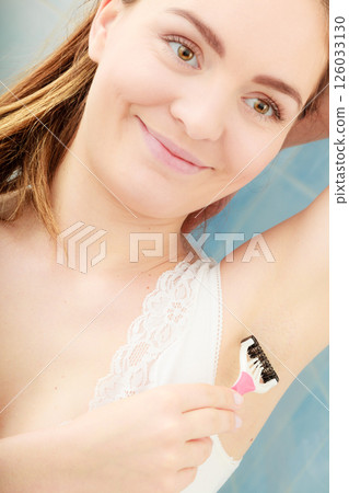 Woman shaving armpit with razor shaver. Hygiene. 126033130