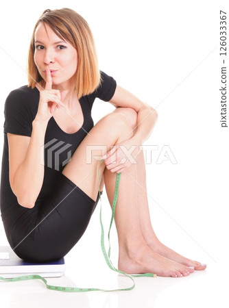 Portrait of a happy woman squatting on scales isolated Portrait of a happy woman squatting on scales isolated 126033367