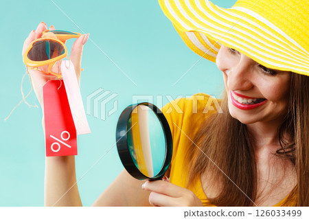 woman choosing glasses searching through magnifying glass woman choosing glasses searching through magnifying glass 126033499
