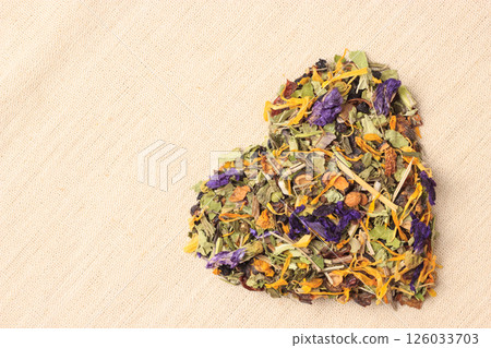 Dried herb leaves heart shaped on burlap surface Dried herb leaves heart shaped on burlap surface 126033703
