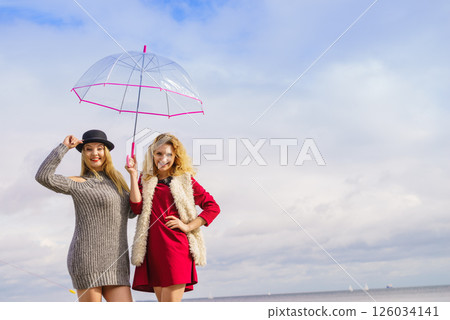 Two fashionable women and umbrella Two fashionable women and umbrella 126034141