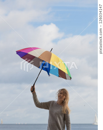 Happy woman holding umbrella Happy woman holding umbrella 126034147