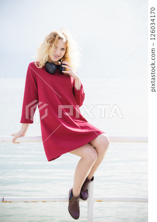 Woman wearing red dress and headphones Woman wearing red dress and headphones 126034170