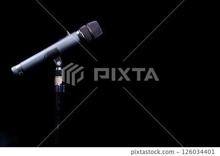 A microphone stand set up in the dark 126034401