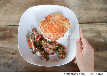 stir fried pork or deep fried pork , fried pork or crispy pork and rice with fried egg or sunny side up egg or pork and rice 126034606