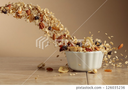 Muesli in motion on a beige background. 126035236