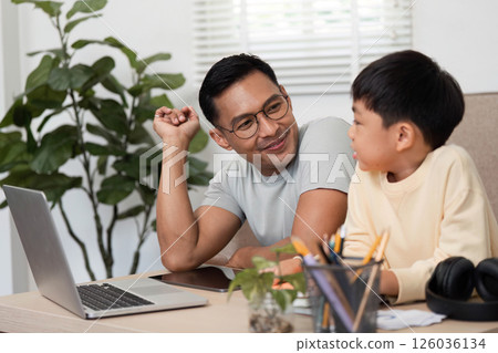 Homeschool learning session between father and son at a desk Homeschool learning session between father and son at a desk 126036134