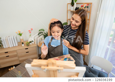 Family time creating art: Engaging mother-daughter painting moment 126036199