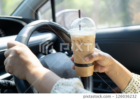 Asian woman driver hold ice coffee cup for drink in car, dangerous and risk an accident. Asian woman driver hold ice coffee cup for drink in car, dangerous and risk an accident. 126036232