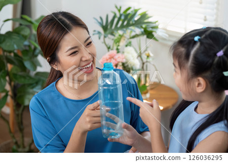 Family Bonding and Recycling Education. A joyful moment showing a child the value of plastic reuse. 126036295