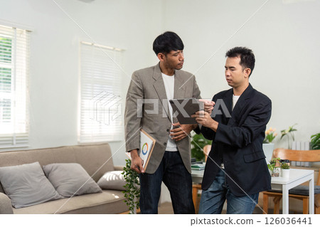 Strategic Business Meeting. Professionals discussing project details and insights in a modern office environment. 126036441