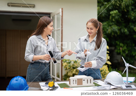 Sustainable Architecture and Teamwork. Two architects presenting a model of an eco-friendly building project. 126036469