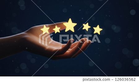 Womans hand gently presenting five shimmering golden star icons floating just above the fingertips, representing a five star rating or review. 126036562