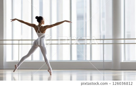 Elegant Ballet Dancer Practicing at Barre in Bright Studio 126036812