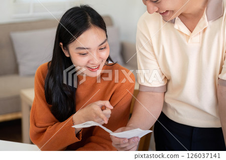 Couple Financial Planning. Engaged couple discussing finances with receipts and calculator at home. Couple Financial Planning. Engaged couple discussing finances with receipts and calculator at home. 126037141
