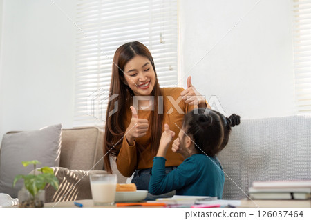 Encouragement and Joy. A mother and daughter celebrate learning achievements. 126037464