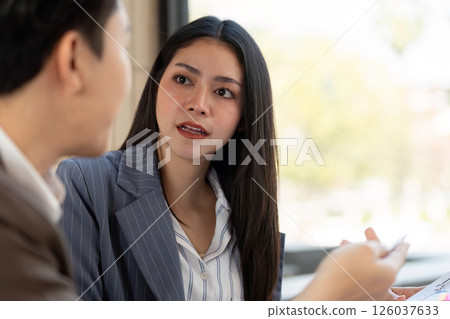 Focused conversation. A female professional discussing plans with her colleague. 126037633