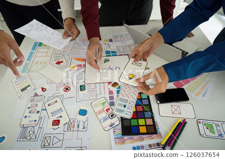 Design Process and Creative Input. Team examining design elements together to enhance digital user experience. Design Process and Creative Input. Team examining design elements together to enhance digital user experience. 126037654