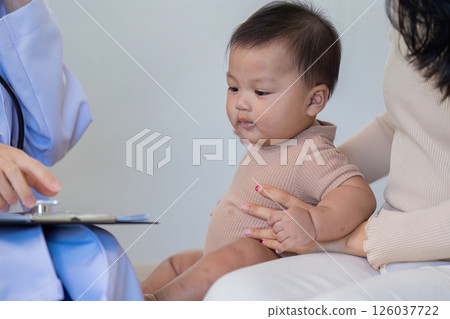Baby's health checkup with doctor and parent support 126037722