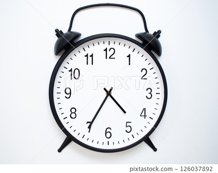 Black Retro Alarm Clock Showing 04:35 or 16:35. Classic Bell Style on White Wood Background. 126037892