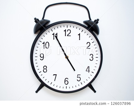 Black Retro Alarm Clock Showing 04:55 or 16:55. Classic Bell Style on White Wood Background. 126037896