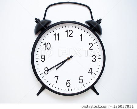 Black Retro Alarm Clock Showing 07:40 or 19:40. Classic Bell Style on White Wood Background. 126037931