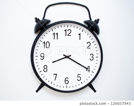 Black Retro Alarm Clock Showing 08:20 or 20:20. Classic Bell Style on White Wood Background. 126037943