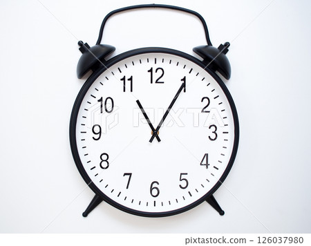Black Retro Alarm Clock Showing 11:05 or 23:05. Classic Bell Style on White Wood Background. 126037980