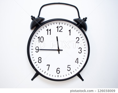 Black Retro Alarm Clock Showing 11:45 or 23:45. Classic Bell Style on White Wood Background. 126038009
