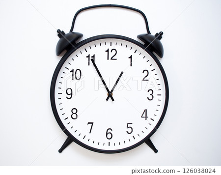 Black Retro Alarm Clock Showing 00:55 or 12:55. Classic Bell Style on White Wood Background. 126038024