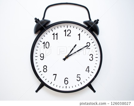 Black Retro Alarm Clock Showing 01:10 or 13:10. Classic Bell Style on White Wood Background. 126038027