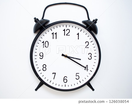 Black Retro Alarm Clock Showing 03:20 or 15:20. Classic Bell Style on White Wood Background. Black Retro Alarm Clock Showing 03:20 or 15:20. Classic Bell Style on White Wood Background. 126038054