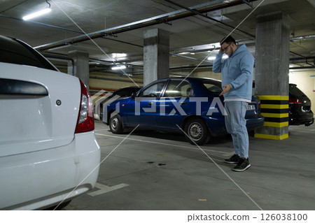 Person in Underground Parking Garage Figure Out of Stolen Car 126038100