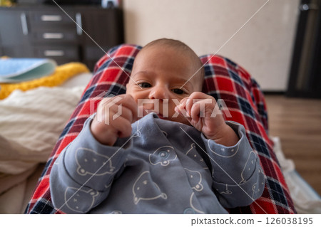 Baby Relaxing on Lap in Cozy Home Setting 126038195