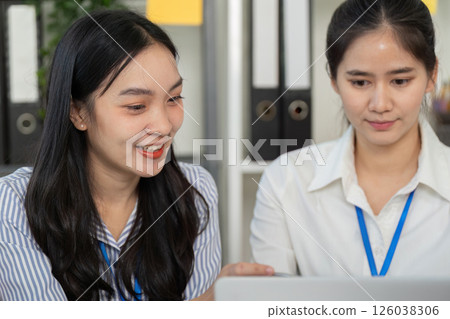 Diverse business team collaborating and discussing strategies with laptop in an office. Diverse business team collaborating and discussing strategies with laptop in an office. 126038306