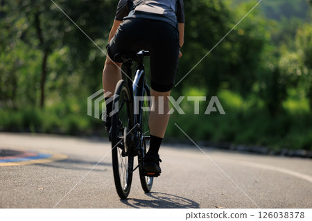 Woman cyclist riding bike at summer park 126038378