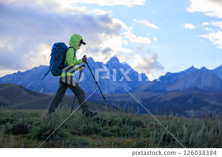 Woman backpacker hiking on high altitude mountains Woman backpacker hiking on high altitude mountains 126038384