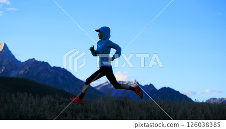 Fitness woman trail runner running on grassland mountain top Fitness woman trail runner running on grassland mountain top 126038385