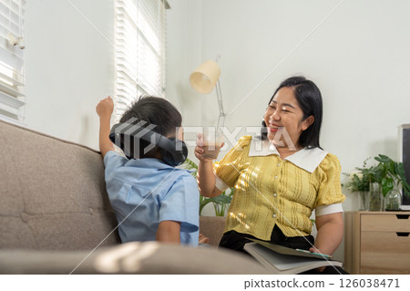 Back to School and Family Bonding. A mother shares a moment with her son, enjoying a drink together. 126038471