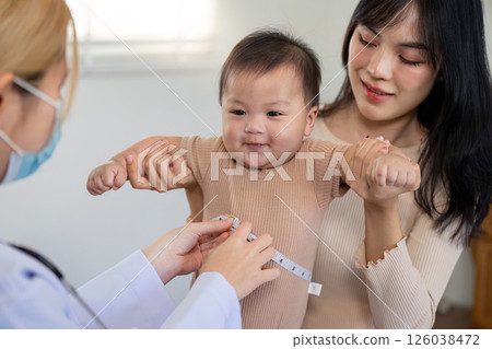 Measuring baby height during a joyful pediatric checkup Measuring baby height during a joyful pediatric checkup 126038472