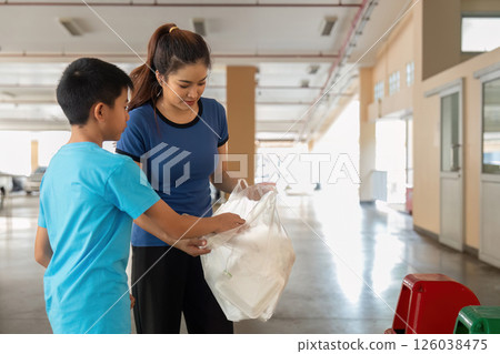 Sustainable Practices and Family Bonding. A mother and child engaging in recycling activities together. 126038475