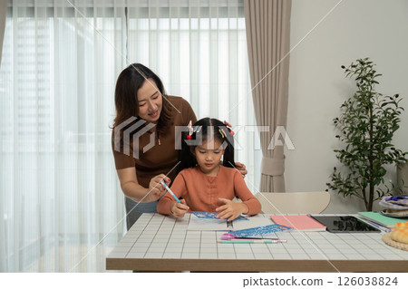 Back to School Engagement and Learning. A mother assists her daughter with a drawing activity, enhancing her skills. 126038824