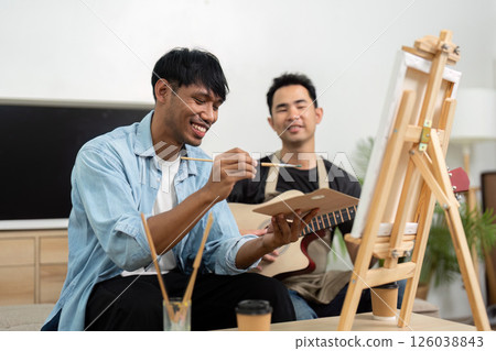 Gay couple bonding over painting and music during leisure time 126038843