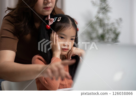 Back to School and Focused Learning. A mother guides her daughter through online tasks, ensuring she stays engaged. 126038866