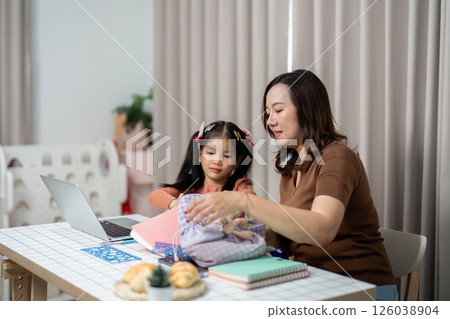 Back to School and Organizing Supplies. A mother and daughter prepare school materials together at home. 126038904