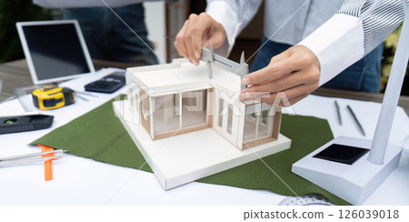 Sustainability and Design Precision. Architects using tools to ensure accuracy in a sustainable building model. 126039018