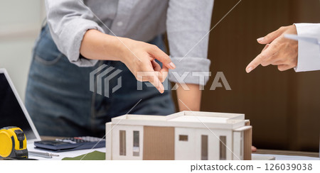 Sustainability and Architectural Design. Professionals discussing a sustainable building model. 126039038